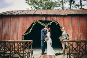 Industrial_Warehouse_Shoot-bride_and_groom_kissing_by_red_building