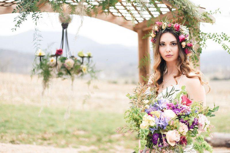 Outdoor_wedding_with_pops_of_color-bride_holding_flowers_with_flower_crown