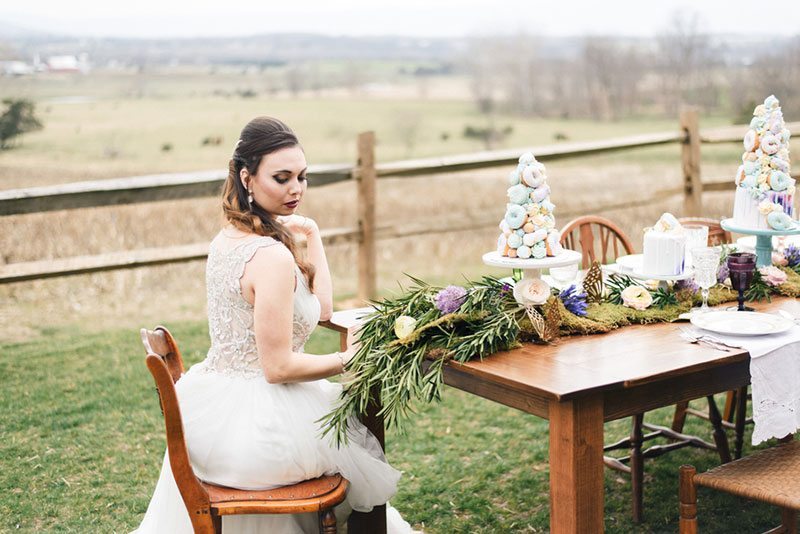 Outdoor_wedding_with_pops_of_color-bride_sitting_at_table