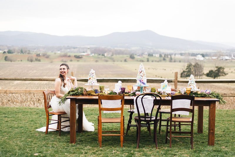 Outdoor_wedding_with_pops_of_color-bride_sitting_at_table_laughing