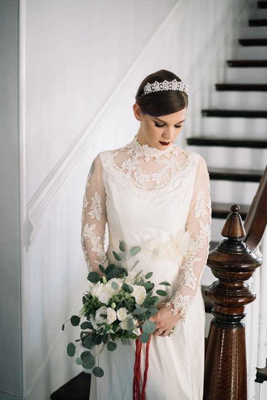 Vintage_Winter_Bridal-bride_by_stairs_looking_down_with_flowers