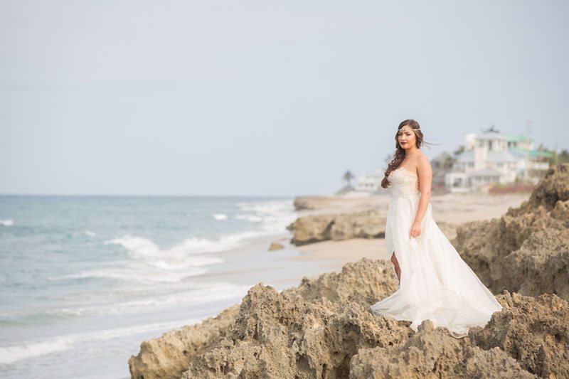 Chic_Coastal_Wedding-bride_standing_on_rocky_beach