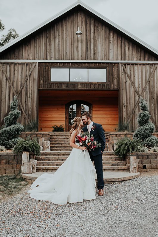 Enchanted_Forrest_Wedding-bride_and_groom_kissing_outside_barn