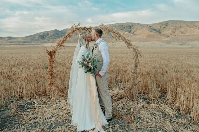 Bountiful Wheat Harvest Bride And Groom Kissing In Field