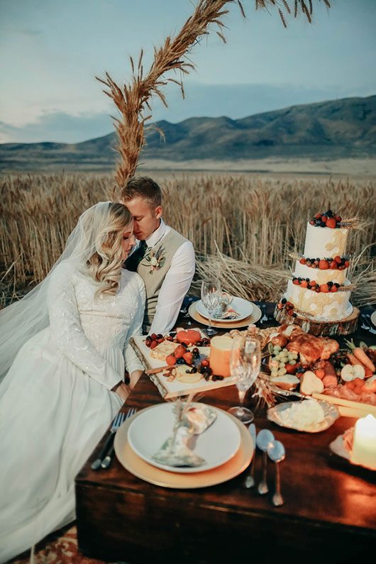 Bountiful Wheat Harvest Bride And Groom Sitting By Food