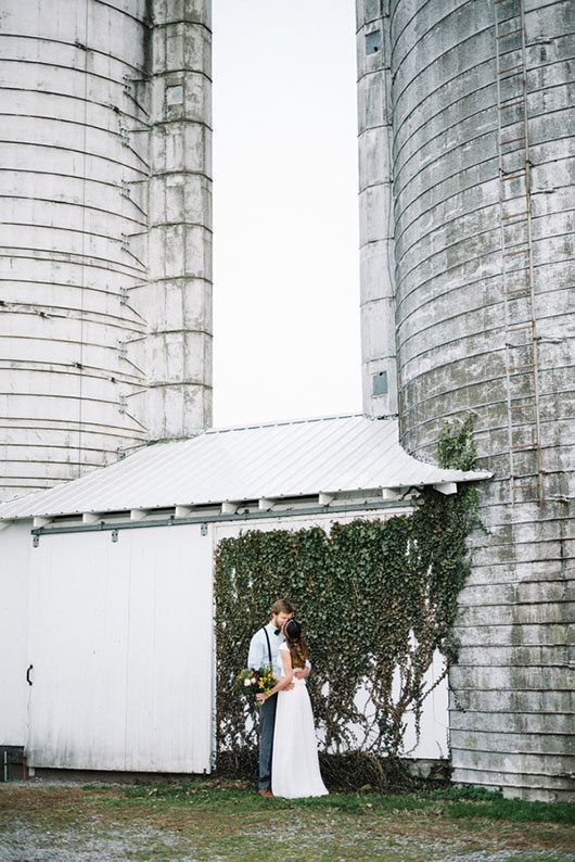 Modern Boho Bride And Groom Kissing In Front Of Building