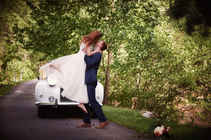 Pink Wedding Bride And Groom Kissing In Front Of Car