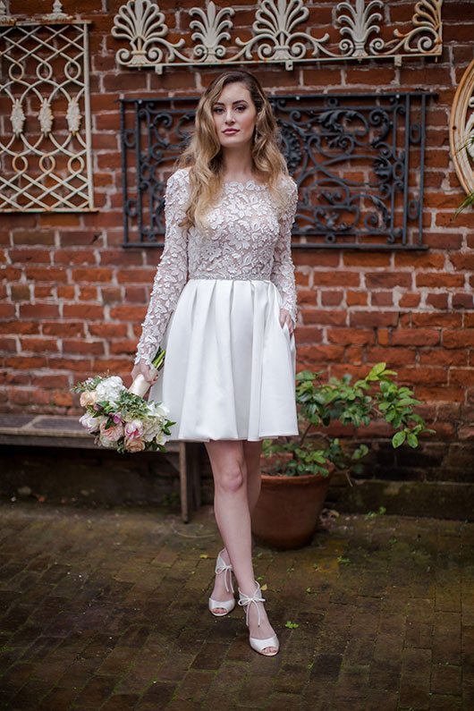 Rime Arodaky Bride Holding Flowers By Brick Wall