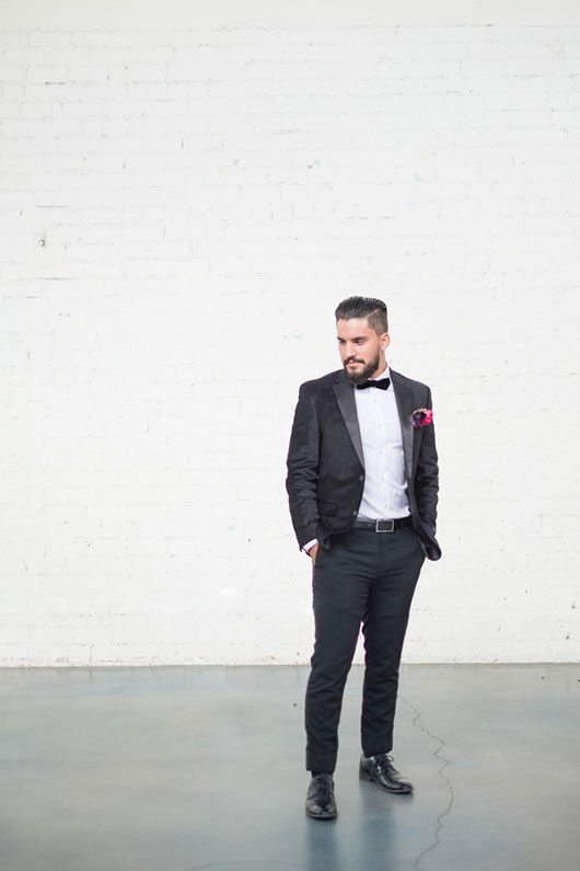 Vintage Copper Groom Standing In Front Of White Wall