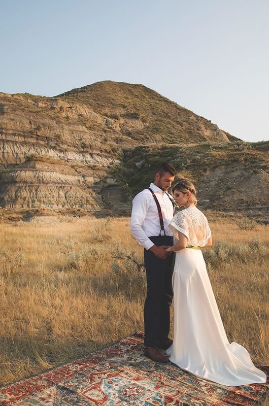 Romantic And Moody Wedding Inspiration Bride And Groom Hold Hands On Rug