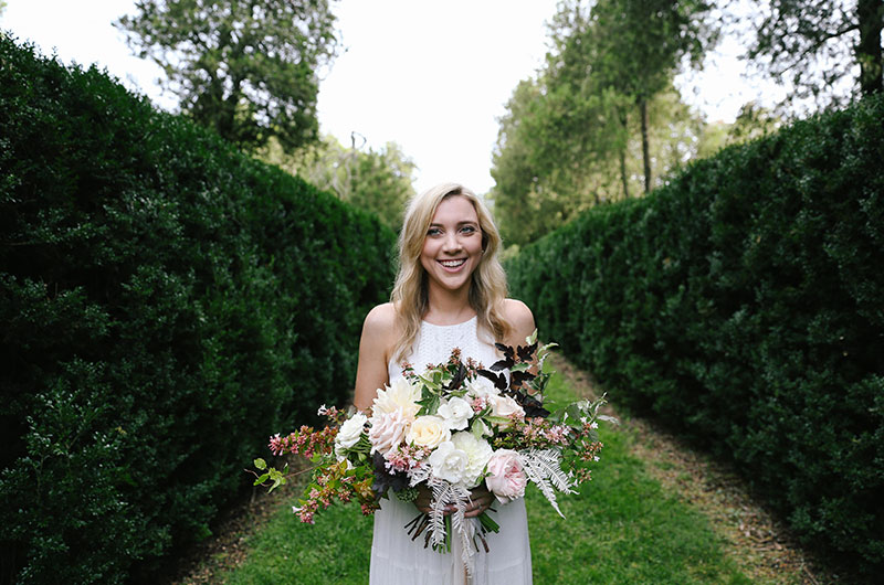 Emily And Justin Emily Holding Bouquet Between Ferns