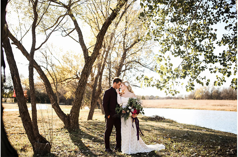 Woodsy Jewel Toned Shoot Wide Shot Couple With Bouquet