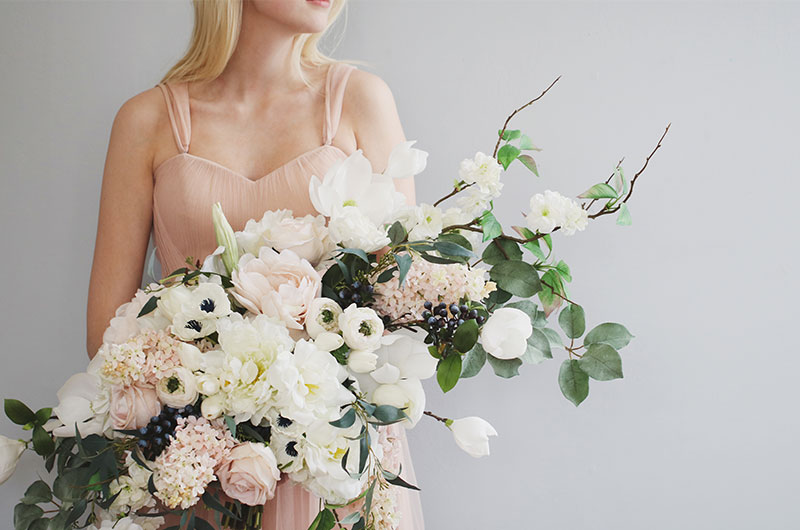 Artificial Vs. Real Flowers For Your Wedding Woman Holding Pink And White Flowers