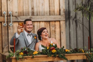 Fall Vibes Are In Full Effect At The Edison Barn Bride And Groom At Dinner Table Toasting