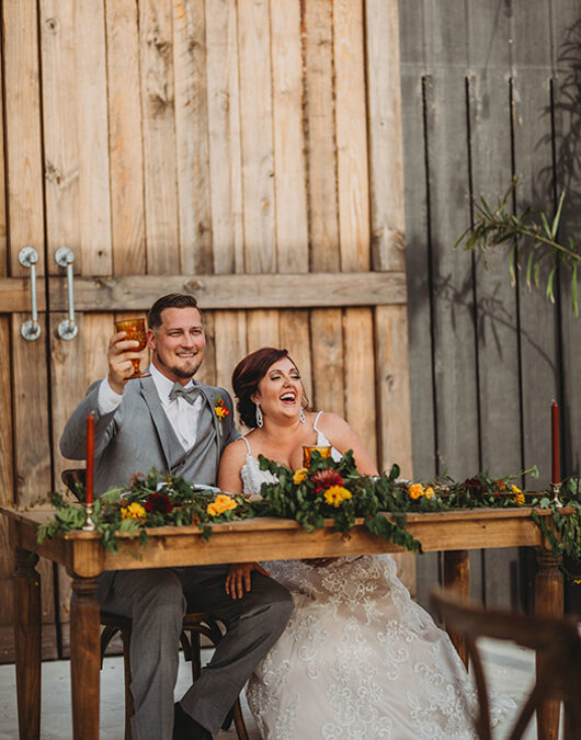 Fall Vibes Are In Full Effect At The Edison Barn Bride And Groom At Dinner Table Toasting