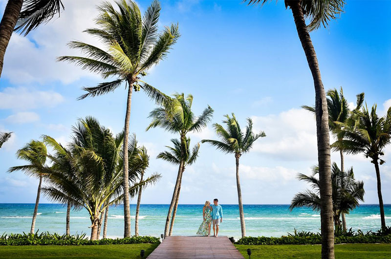 Grand Velas Riviera Maya Mexico Campana Grand Class Couple With Palm Trees And Beach Background