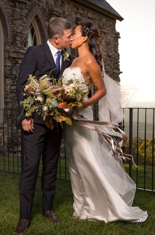 Bride And Groom Kissing With Ozark Mountains At Top Of The Rock View 1