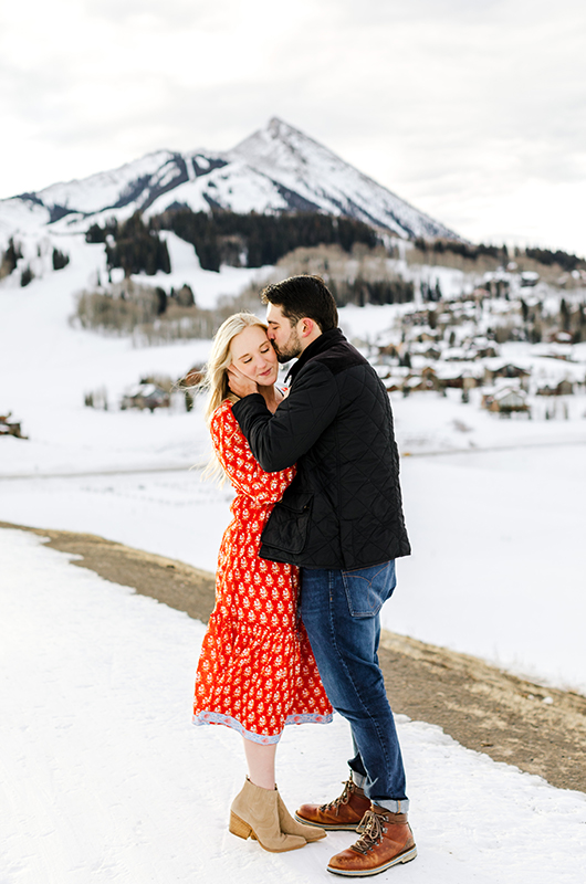 Callie And Kyle’s Colorado Mountainside Engagement Kyle Kissing Callie On The Cheek