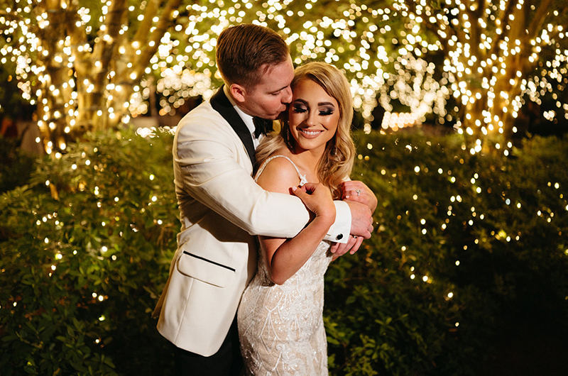 Stacey Asaro And Ryan Gaudet Marry At The Luxury Southern Oaks New Orleans Groom Kisses Bride On Cheek In Front Of Light Up Trees Copy 2
