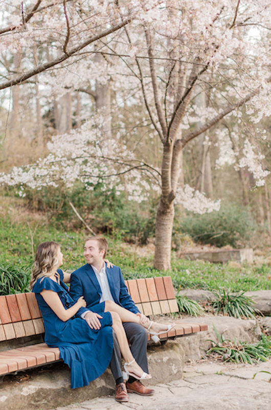 Kristin And Hunters Romantic Cherry Blossom Engagement Smiling On Bench Copy