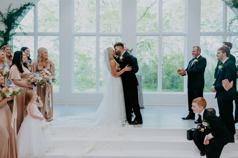 Paula and Ayson Marry in a Whimsical Wedding at Legacy Acres Arkansas Bride and Groom Kissing at Ceremony