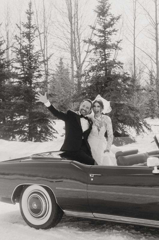 Jenny Tolman and Dave Brainard were married under the majestic Teton Mountain Range at Split Creek Ranch in Jackson Wyoming Sitting on Car