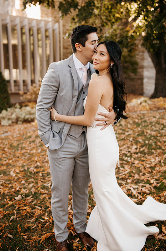 A Beautiful Ballroom Reception at the Four Seasons Hotel Minneapolis Groom Kissing Bride on the Cheek