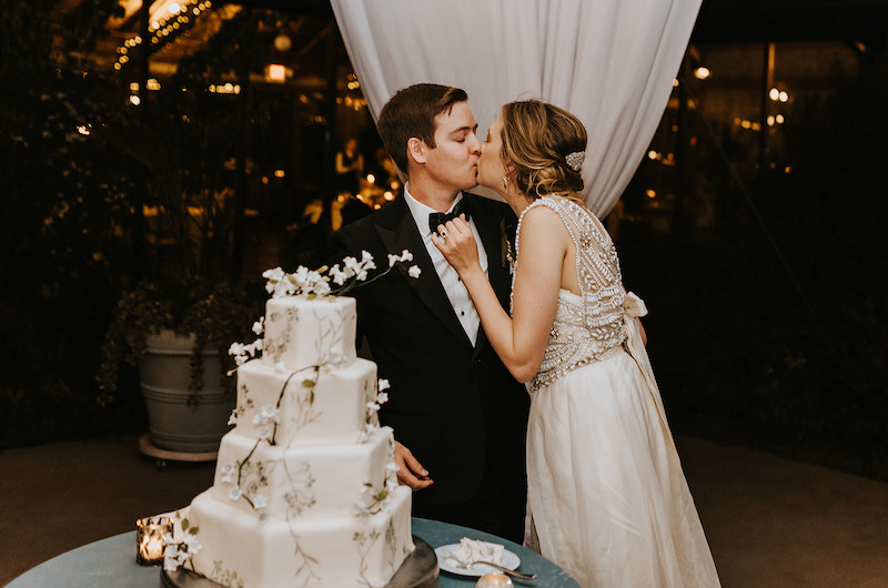 emily and matt marry in a classic church ceremony with a vintage reception bride and groom cutting cake