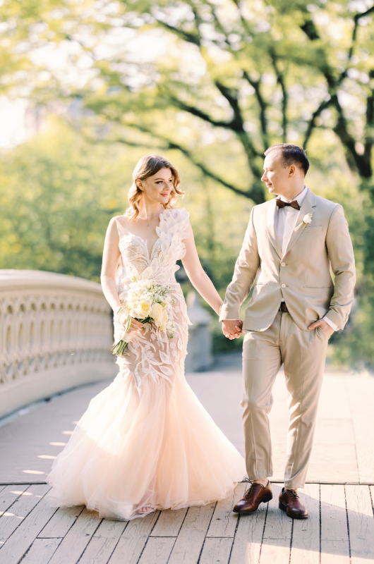 new york styled shoot central park couple holding hands on bridge
