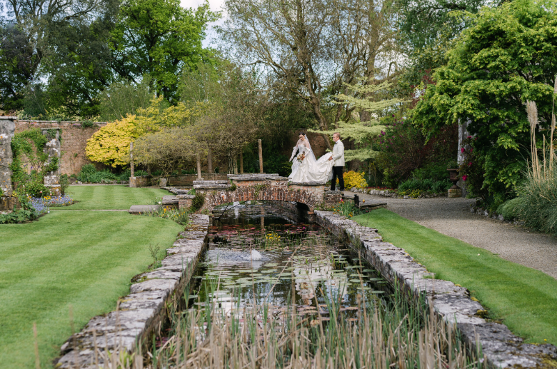 dromoland castle styled shoot couple standing on lake horizontal