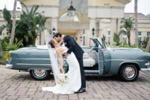 Trendsetter Award Hammock Beach Bride Groom Kissing in front of Car