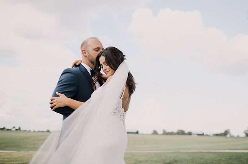 Tina Shtayyeh And Geno Tartell Bride And Groom With Brides Veil Draping Over Elegantly