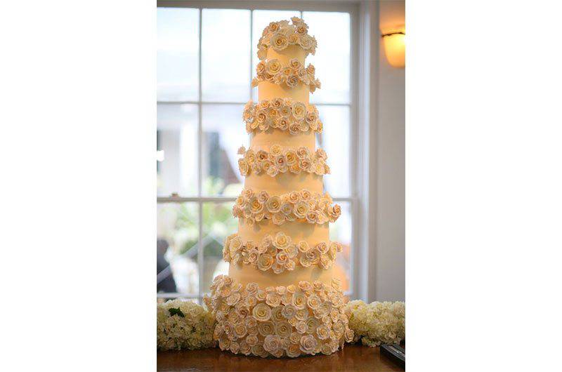 Signature Occasions tall wedding cake tiered with white flowers