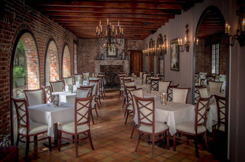 Broussards Restaurant and Courtyard Square Tables draped in white linens arched brick windows