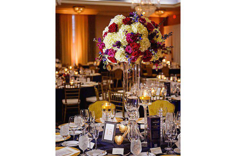 Weddings by Lulu tall floral centerpiece navy blue gold round tables