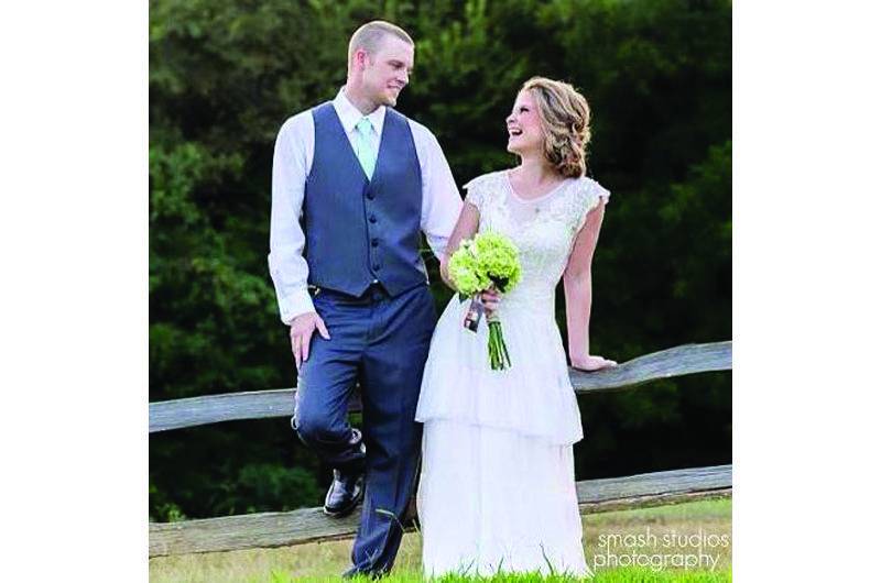 The Barefoot Bride bride and groom on fence looking