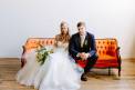The Big Fake Wedding bride and groom together orange couch