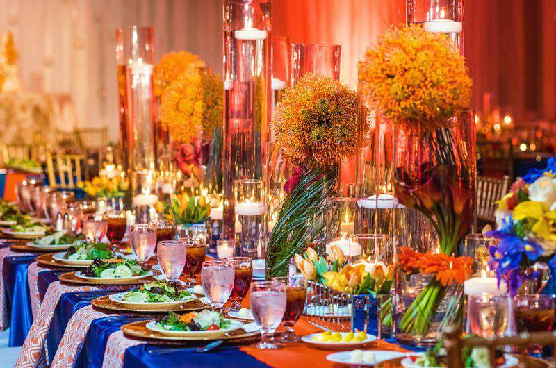 Southern Event Planners colorful table setting floating candles tall floral arrangements