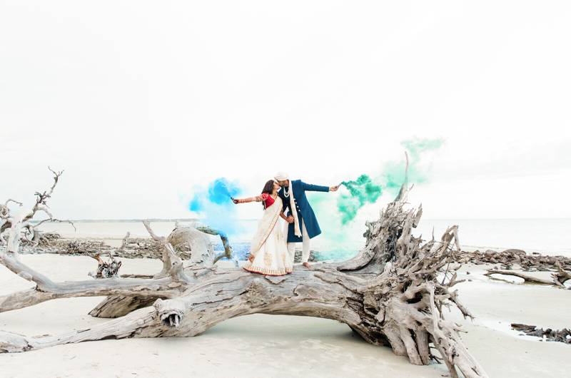 Dreamiest Costal Wedding In The Golden Isles Bride And Groom Standing On Driftwood With Colorful Smoke