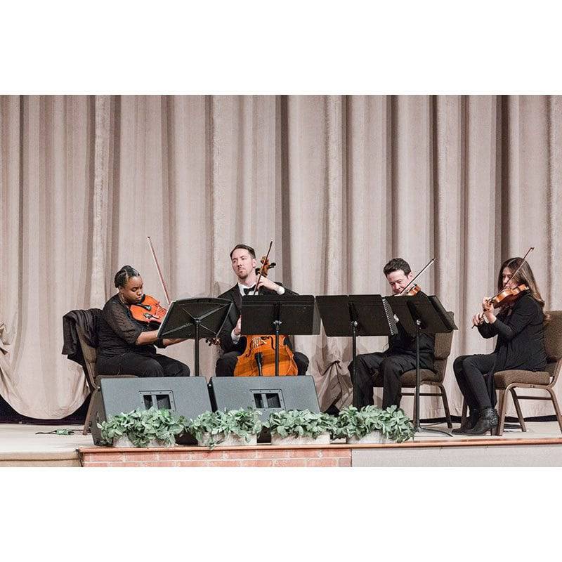 Simply Strings 4 piece cello violin viola performing on stage