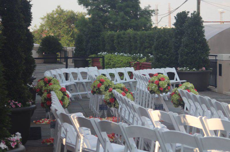 The Jaxson Wedding Ceremony seating outdoor floral arrangements in aisle